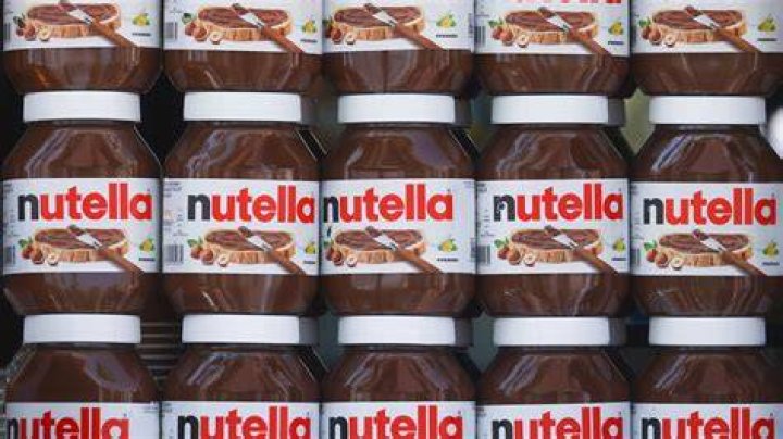 Stack of three Nutella chocolate chip cookies next to a spoonful of Nutella